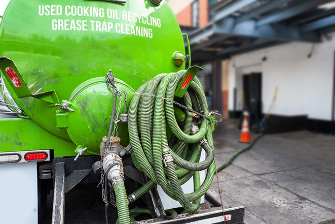 a technician pumping a grease trap in a commercial building in Moscow